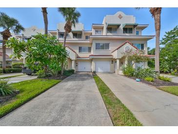 Two story townhome with attached garage and lush landscaping at 4654 Mirabella Ct, St Pete Beach, FL 33706