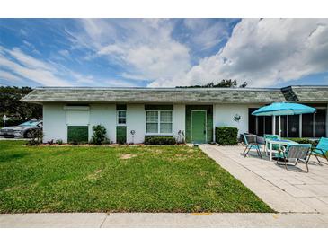 Inviting single-story home with a lush lawn and a charming outdoor seating area at 7787 39Th N Ter # 7787, St Petersburg, FL 33709