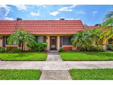 Exterior view of a charming condo with landscaping at 19029 Us Highway 19 N # 12B, Clearwater, FL 33764