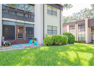 A charming condo with lush landscaping and a cozy patio area at 2400 Winding Creek Blvd # 25-101, Clearwater, FL 33761