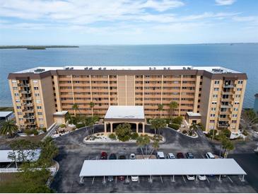 Aerial view of a waterfront condo building with parking and a waterfront view at 9 Haig Pl # 612, Dunedin, FL 34698