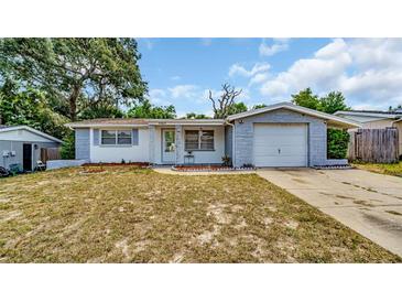 One-story home with gray block exterior and attached garage at 9406 Rainbow Ln, Port Richey, FL 34668