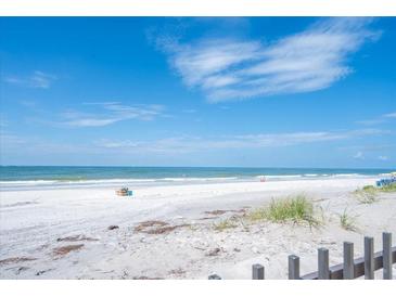 Expansive view of the sandy beach with blue water and clear skies at 14300 Gulf Blvd # 206, Madeira Beach, FL 33708