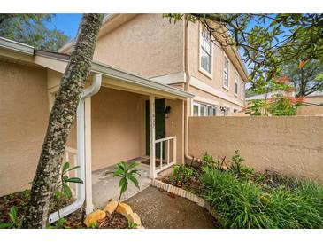 Tan colored townhome exterior with walkway and landscaping at 11837 Wildeflower Pl # 11837, Temple Terrace, FL 33617