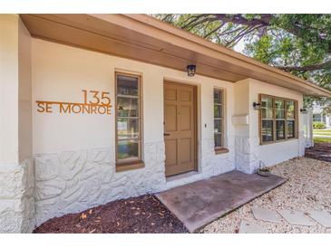 Updated home exterior featuring a charming front entrance and landscaping at 135 Se Monroe N Cir, St Petersburg, FL 33703