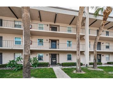 Two-story condo building with palm trees and landscaping at 8693 Bardmoor Blvd # 202B, Seminole, FL 33777