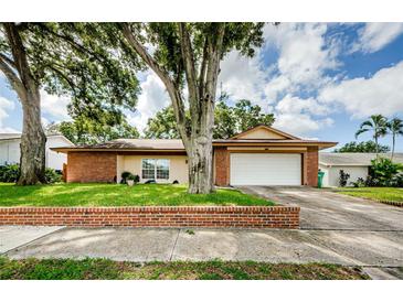 Brick ranch home with attached garage and landscaping at 2208 Citrus Valley Cir, Palm Harbor, FL 34683