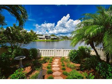 Landscaped backyard with stone path, bird bath, and peaceful lake view at 903 San Carlos Ne Ave, St Petersburg, FL 33702