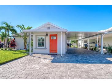 Brightly colored house exterior with a paved driveway at 142 Beach Ave, Redington Shores, FL 33708