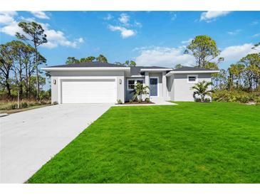 Single-story home with gray exterior, white garage door, and lush lawn at 13459 Keystone Blvd, Port Charlotte, FL 33981