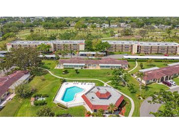 Community aerial shot showcasing the pool, landscaping, golf course, and multiple condo buildings at 12200 Vonn Rd # 1209, Largo, FL 33774