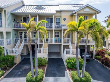 Inviting multi-level condo with palm trees and a metal roof, nestled in a well-maintained community at 603 Bahia Beach Blvd, Ruskin, FL 33570