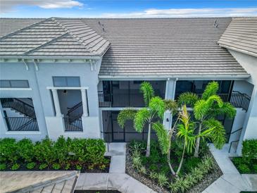 Close aerial view of a condo unit with landscaping featuring palms and other greenery, well maintained complex at 14204 Heritage Landing Blvd # 714, Punta Gorda, FL 33955