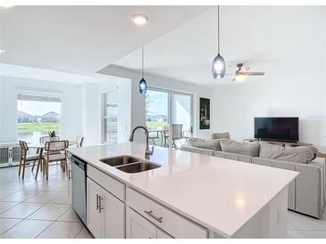 Bright open-plan living room with modern island kitchen, dining area, and stylish contemporary furniture at 14204 Heritage Landing Blvd # 714, Punta Gorda, FL 33955