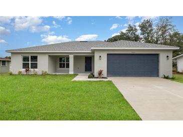 Charming single-story home featuring a well-manicured lawn and a two-car garage at 3067 Newbury St, Port Charlotte, FL 33952