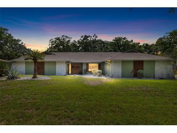 Inviting single-story home featuring manicured lawn, mature trees, and beautiful landscaping, providing great curb appeal at 4301 Hudson Ln, Tampa, FL 33618