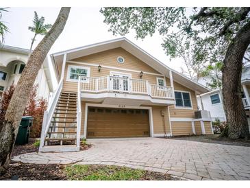 Two-story home featuring a balcony, stairs, a two car garage and a well-kept paved driveway at 5169 Oxford Dr, Sarasota, FL 34242