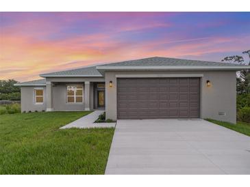 Beautiful single-story home featuring an attached garage, manicured lawn, and neutral-toned stucco exterior at 14362 San Domingo Blvd, Port Charlotte, FL 33981