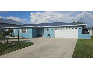 Charming blue one-story home with a well-manicured lawn and a spacious driveway leading to an attached two-car garage at 3510 Magnolia Way, Punta Gorda, FL 33950