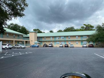 Front view of a two-story apartment building with ample parking at 5822 Congress St # 104, New Port Richey, FL 34653