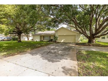 Single story home with driveway and mature landscaping at 12709 Clock Tower Pkwy, Hudson, FL 34667