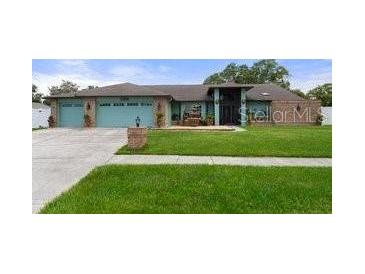 Two-story house with a three-car garage and landscaped yard at 6096 Kinlock Ave, Spring Hill, FL 34608