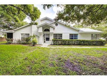 White single-story house with well-manicured lawn and landscaping at 2727 Featherstone Dr # 2727, Holiday, FL 34691