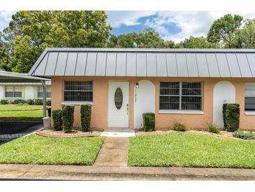 Condo exterior with gray roof and peach-colored siding at 11937 Bayonet Ln, New Port Richey, FL 34654