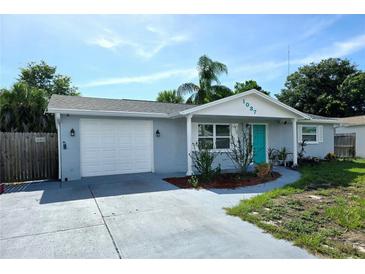 House exterior with a gray facade and teal front door at 1037 Chelsea Ln, Holiday, FL 34691