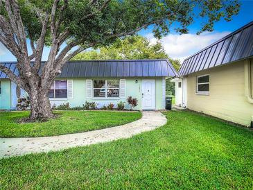 Quaint condo with a lush green lawn and walkway at 11836 Carissa Ln # B, New Port Richey, FL 34654