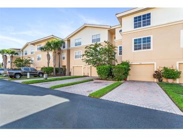 Tan townhouses with garages, paved driveways, and landscaping at 5614 Red Snapper Ct, New Port Richey, FL 34652