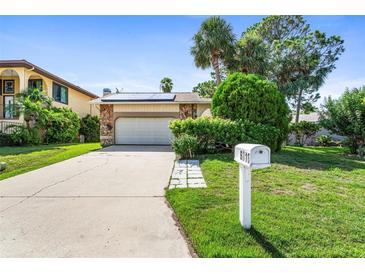Ranch style home with a two-car garage and a neat lawn at 6316 Spoonbill Dr, New Port Richey, FL 34652
