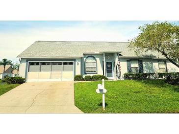 Single-story home with grey roof, attached garage, and well-maintained lawn at 4201 Avanti Cir, New Port Richey, FL 34655