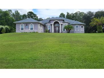 Two-story home with a large front yard at 11033 Baywind Ct, Weeki Wachee, FL 34613