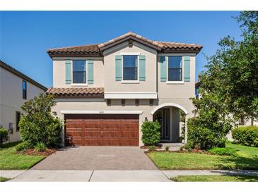 Charming two-story home features a well-manicured lawn, tile roof, blue shutters, and a two car garage at 3893 Burdick Loop, Odessa, FL 33556