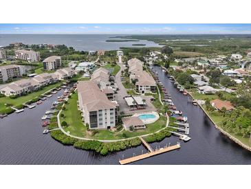 Waterfront condo community featuring boat docks, swimming pool, lush landscaping, and water views at 8210 Aquila St # 227, Port Richey, FL 34668