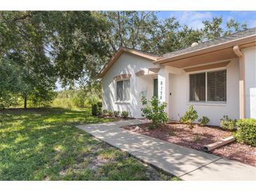 White house exterior with green door, walkway, and landscaping at 8175 Sturbridge Ct # 0, Weeki Wachee, FL 34613