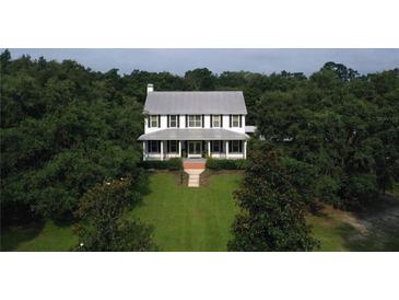 Two story home with metal roof and lush landscaping at 23337 Lake Lindsey Rd, Brooksville, FL 34601