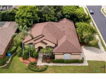 An aerial view of a tan one-story home with a brown roof, surrounded by green trees and grass at 1641 Bayfield Ct, Trinity, FL 34655