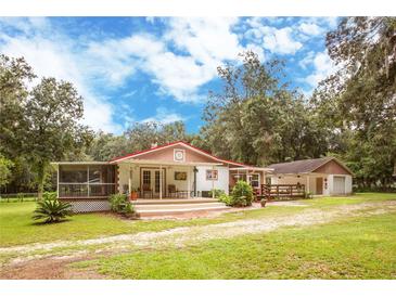 Charming ranch home with a large screened porch, deck, and fenced yard at 24514 Audubon Dr, Brooksville, FL 34601