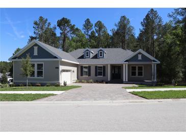 Charming home with a paved driveway, attached garage, manicured lawn and a traditional architectural style at 4676 Hickory Oak Dr, Brooksville, FL 34601