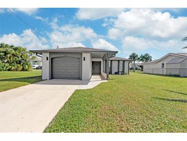 Charming single-story home featuring a well-maintained lawn and gray colored architectural details, including a two-car garage at 7332 Mako Dr, Hudson, FL 34667