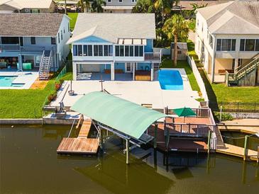 Aerial view of waterfront home with private pool, dock, and boat lift at 7637 Hatteras Dr, Hudson, FL 34667
