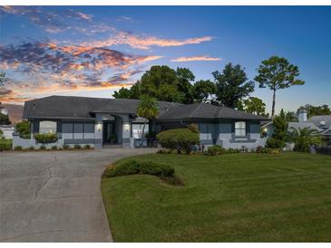 Attractive home exterior at dusk with landscaping and paved driveway at 8721 Latham Dr, Hudson, FL 34667