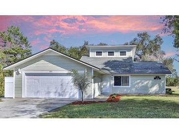 Charming two-story home with a white garage door and landscaping at 10221 Elgin Blvd, Spring Hill, FL 34608