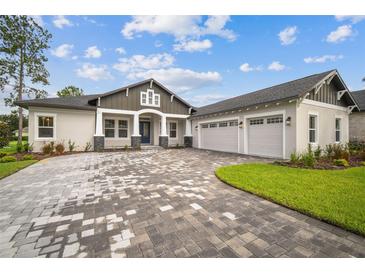 New construction home with three-car garage and paver driveway at 19395 Sheltered Hill Dr, Brooksville, FL 34601