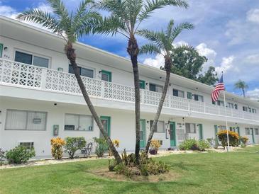 Exterior view of a light-colored apartment building with landscaping at 11200 86Th Ave # 204, Seminole, FL 33772