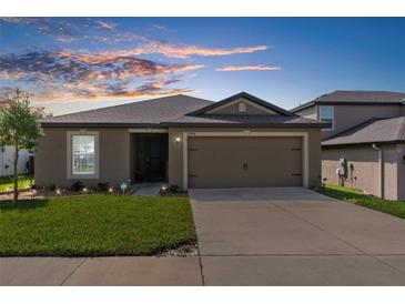 Two-story house with a neutral color scheme and a two-car garage at 12894 Impatiens St, Spring Hill, FL 34609