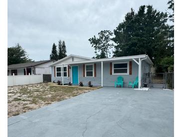 Charming single-story home with a bright blue door, gray exterior and updated landscaping at 4041 Las Vegas Dr, New Port Richey, FL 34653
