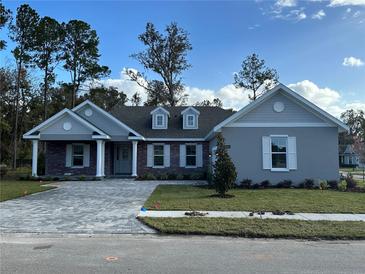 Charming two-story home with a brick and siding exterior, paved driveway, and landscaped yard at 19364 Sheltered Hill Dr, Brooksville, FL 34601